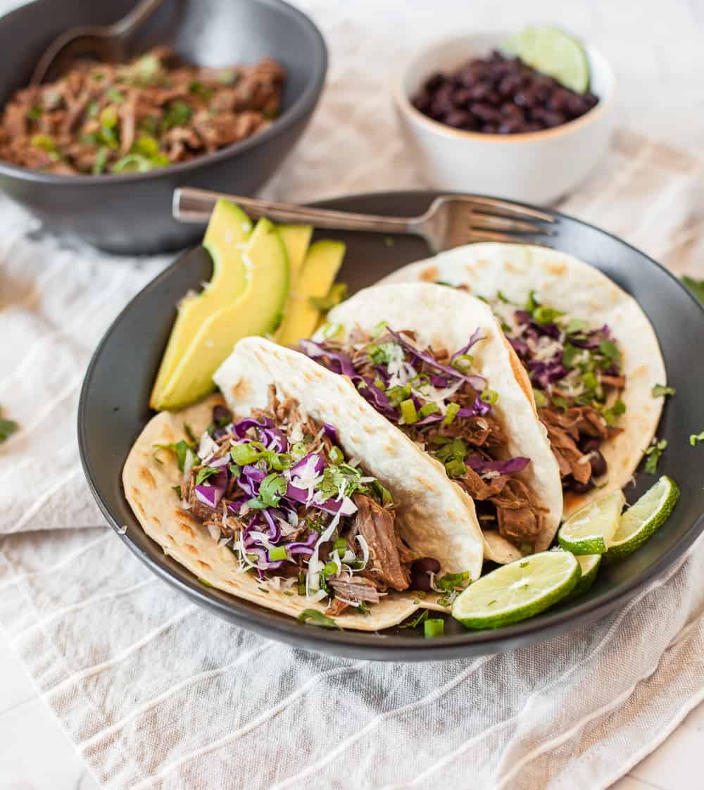 Our Instant Pot Shredded Beef Tacos are perfect for Taco Tuesdays or meal prep on Sundays! This simple shredded beef cooks up juicy and flavorful in the pressure cooker and can be used for many recipes besides tacos. | MarathonHandbook.com #instantpot #pressurecooker #beef #tacos