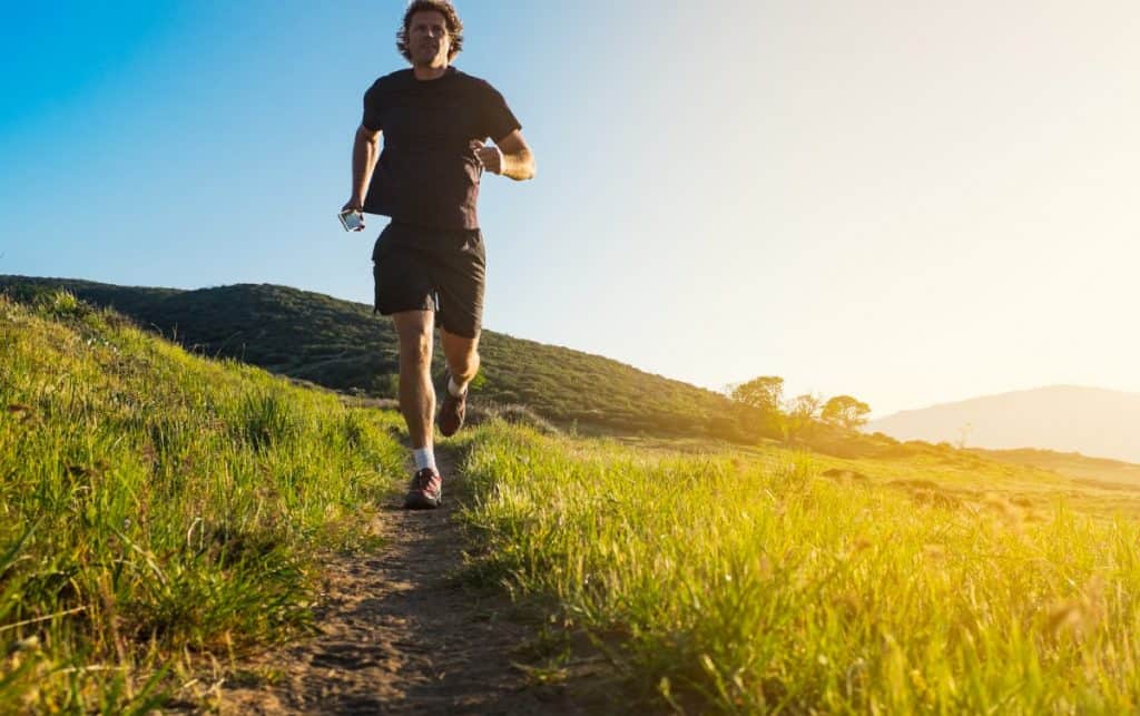 un hombre corriendo en un sendero de colina