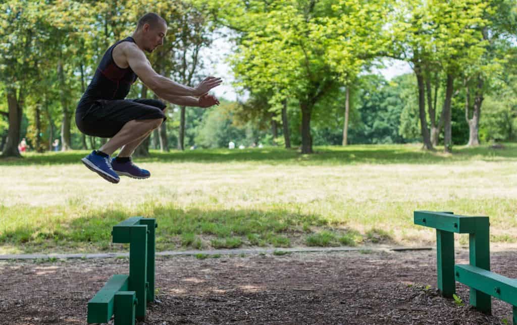 Man jumping over metal benches