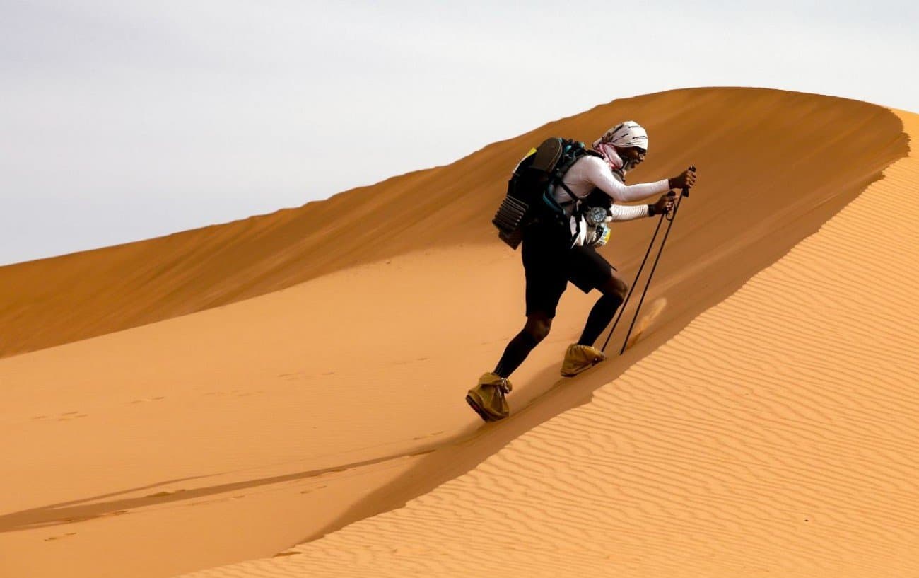 a marathon man climbing on desert mountain