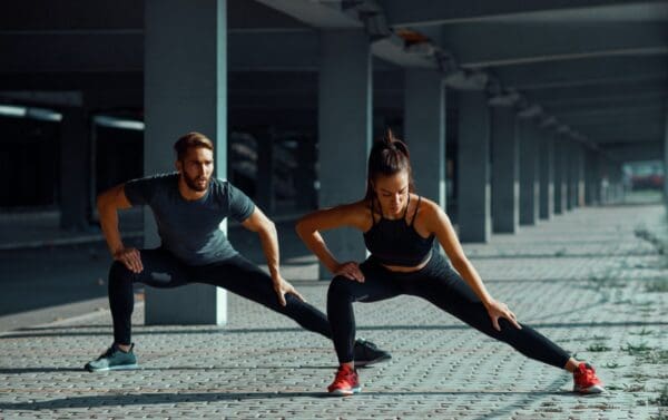 a marathon couple doing dynamic stretching for marathon