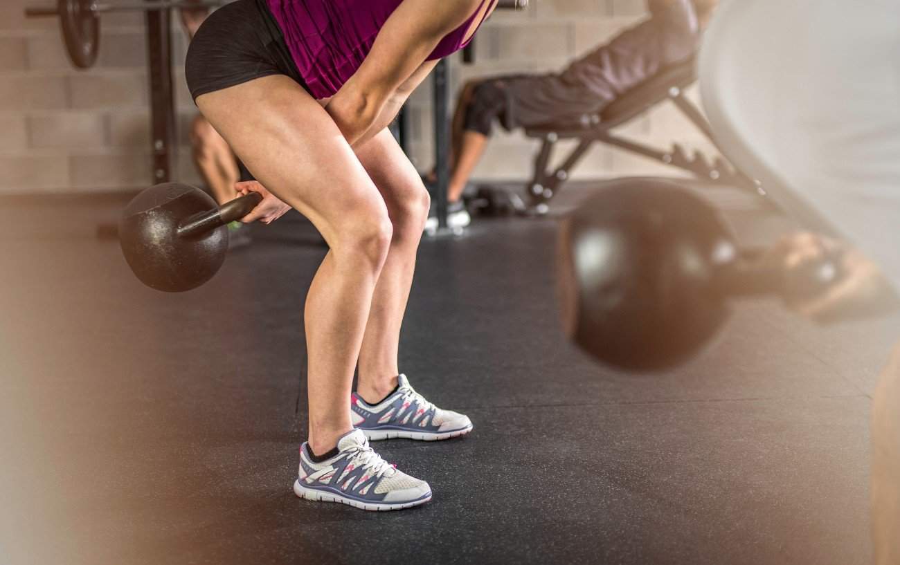 Una persona haciendo un balanceo con kettlebell.