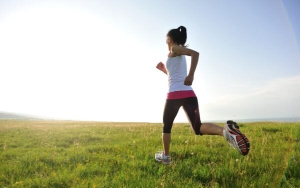 a marathon girl running on beautiful green field