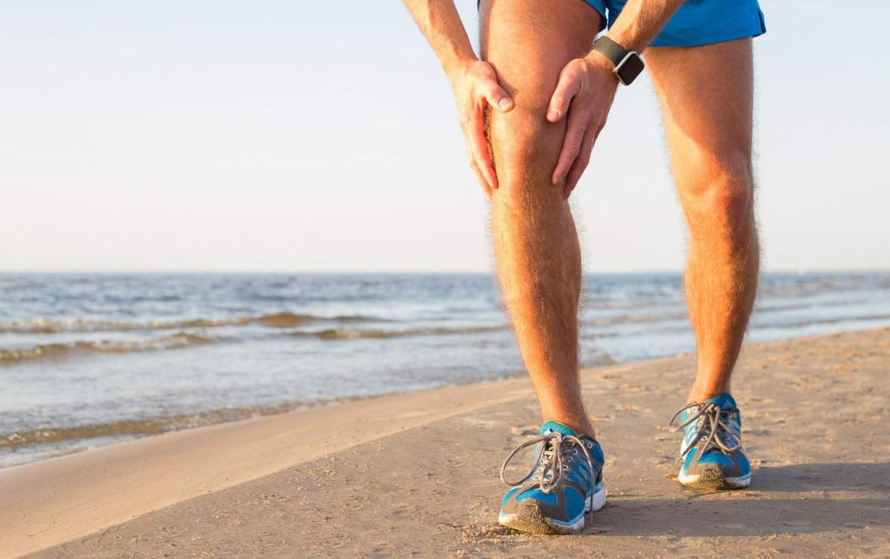 Una persona sosteniendo su rodilla.