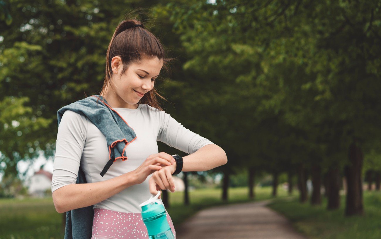 a lady in running gear checking her watch