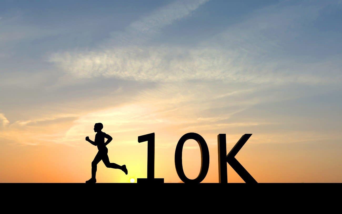 Silhouette saying 10k beside runner against sunset