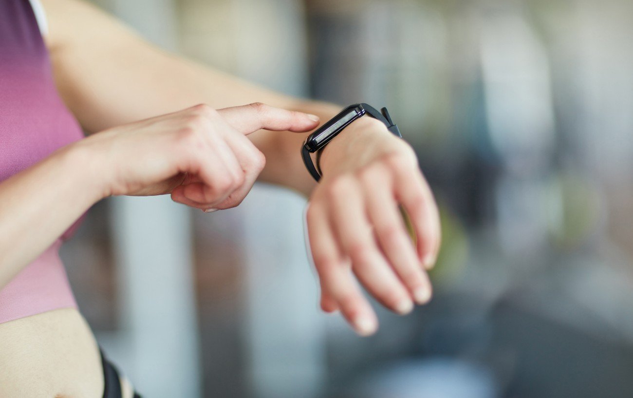 Una persona señalando su reloj de entrenamiento.