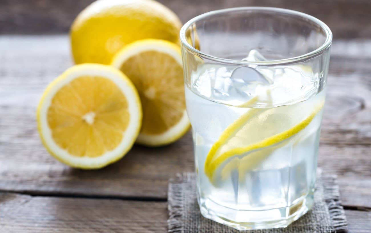 Un vaso de agua con rodajas de limón.