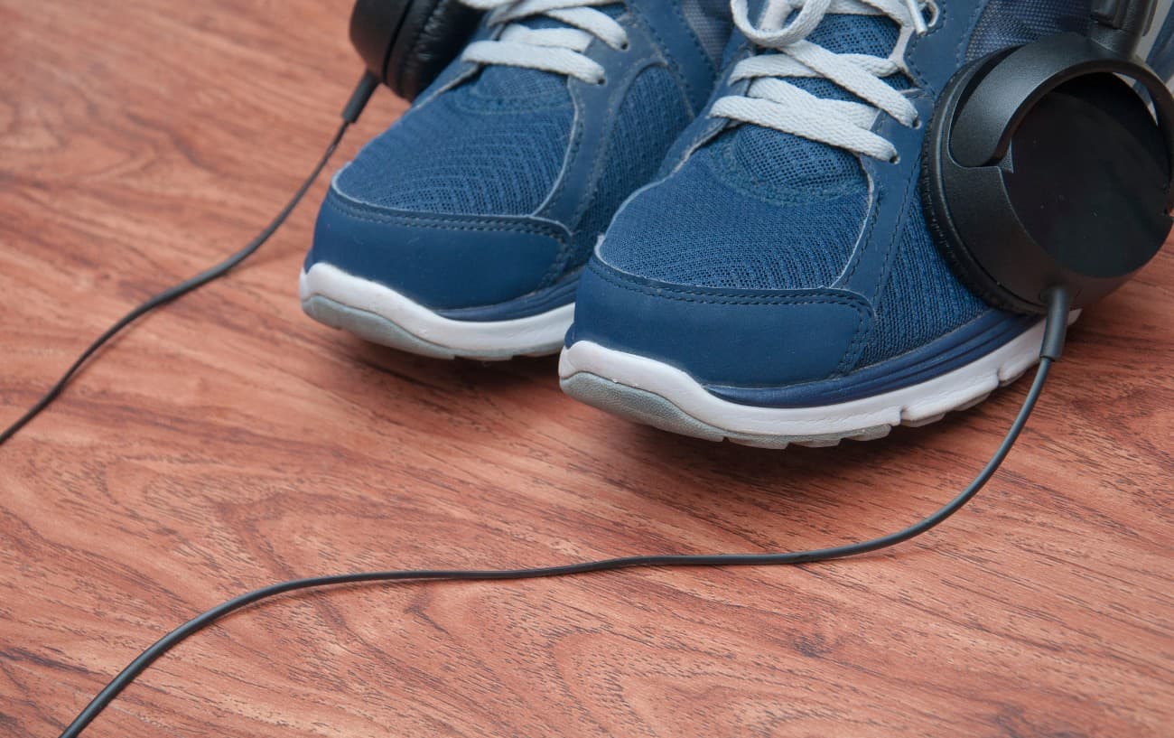 Un par de zapatillas de running con un par de auriculares encima.