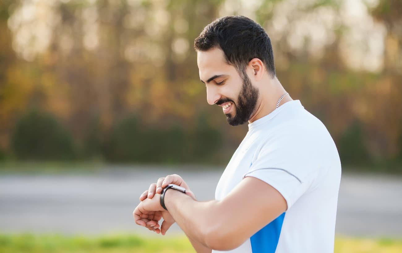 A runner looking down at his watch. 