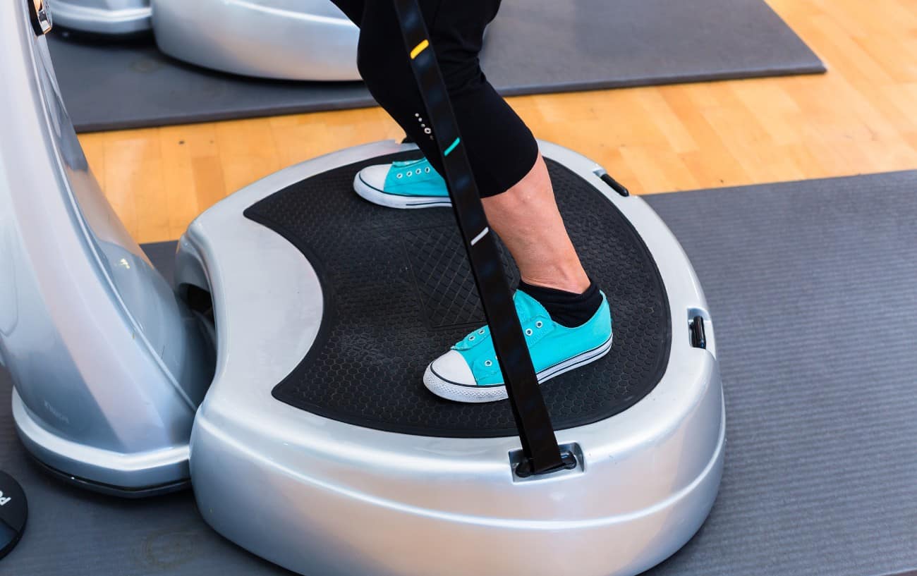 A person on a whole-body vibration machine.