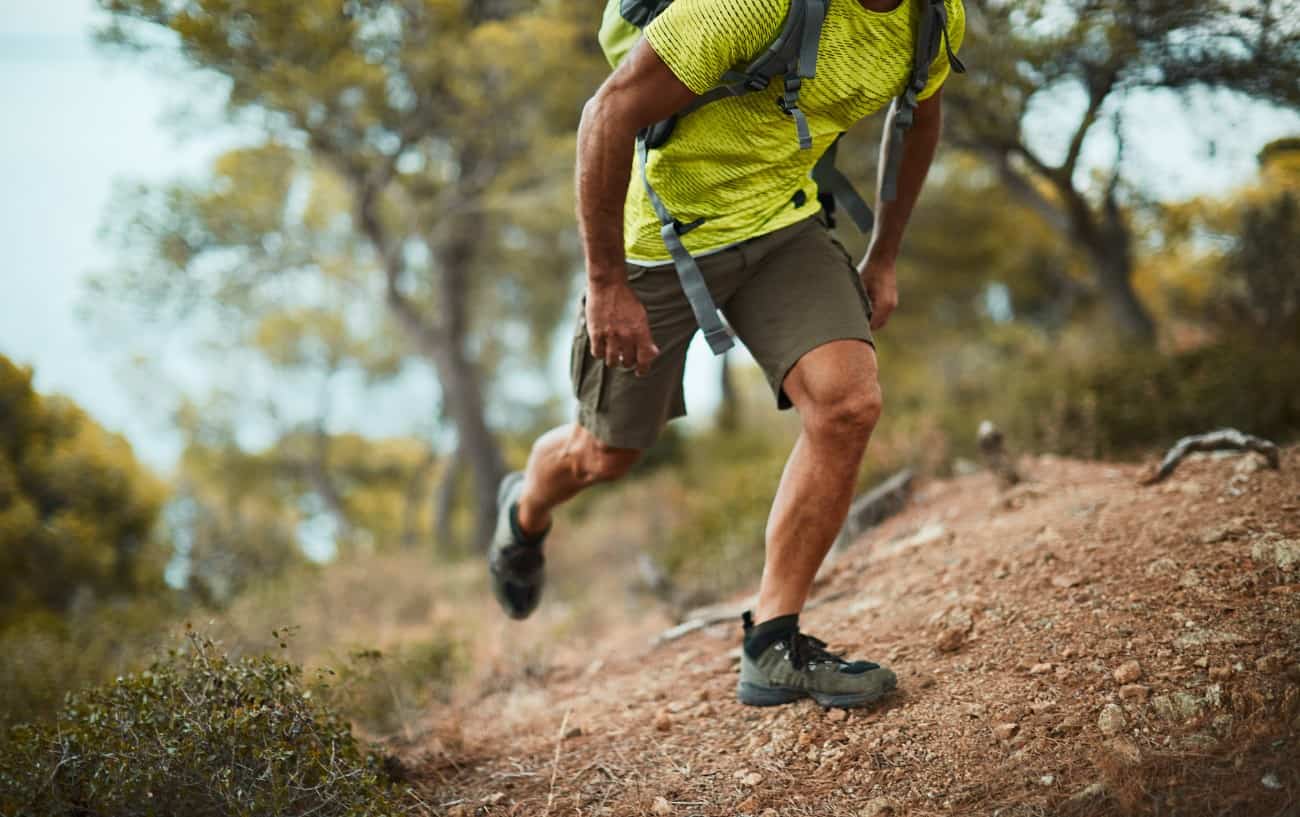 Un corredor de trail caminando cuesta arriba.