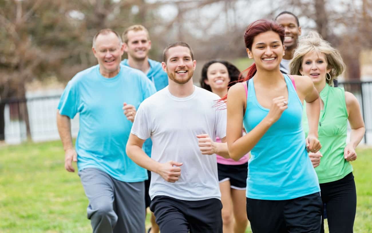 Un grupo de personas corriendo tranquilamente y sonriendo.