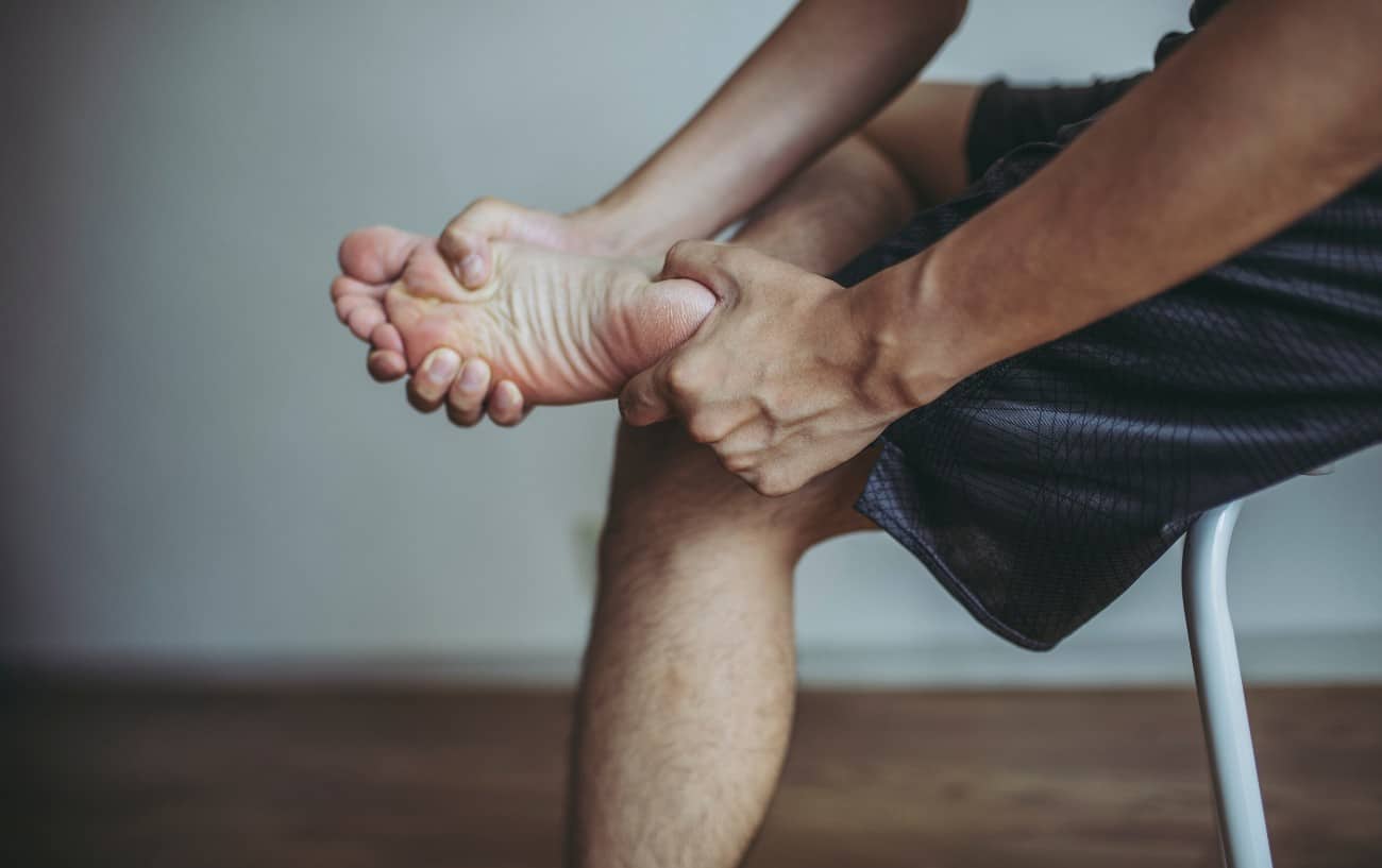 A person stretching their foot. 