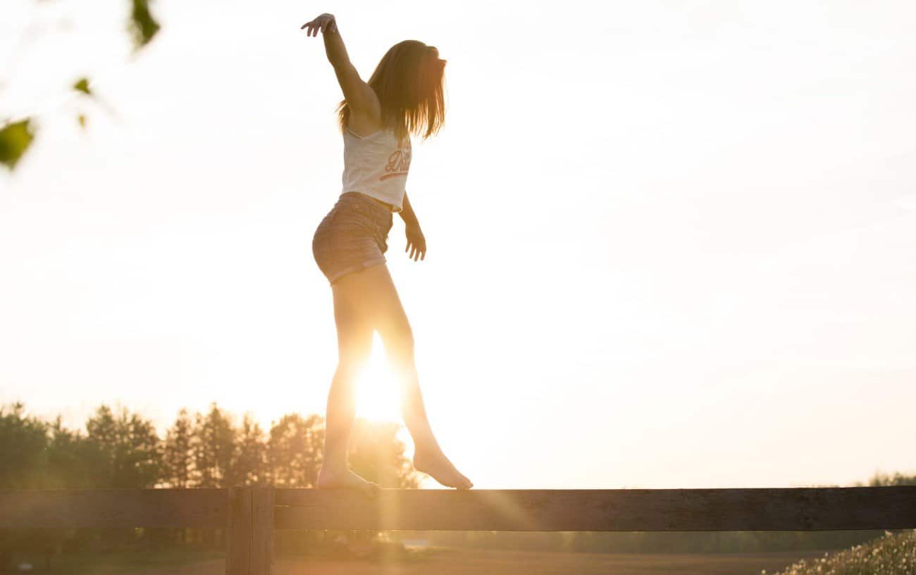 A person balancing on a log.