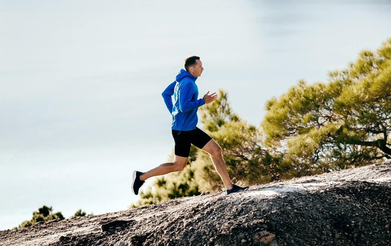 He runs well. Бегун в синем. Бегун на фоне гор фото. Run in Mountain. Мускулистый мужчина взбирается на холм.