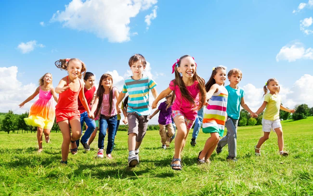 Niños corriendo en un campo.