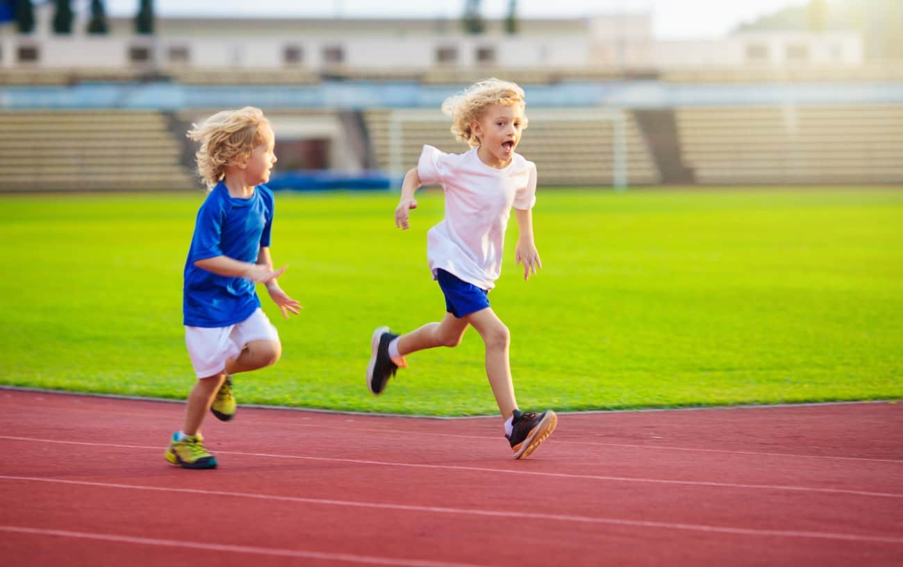 Dos niños corriendo en una pista.