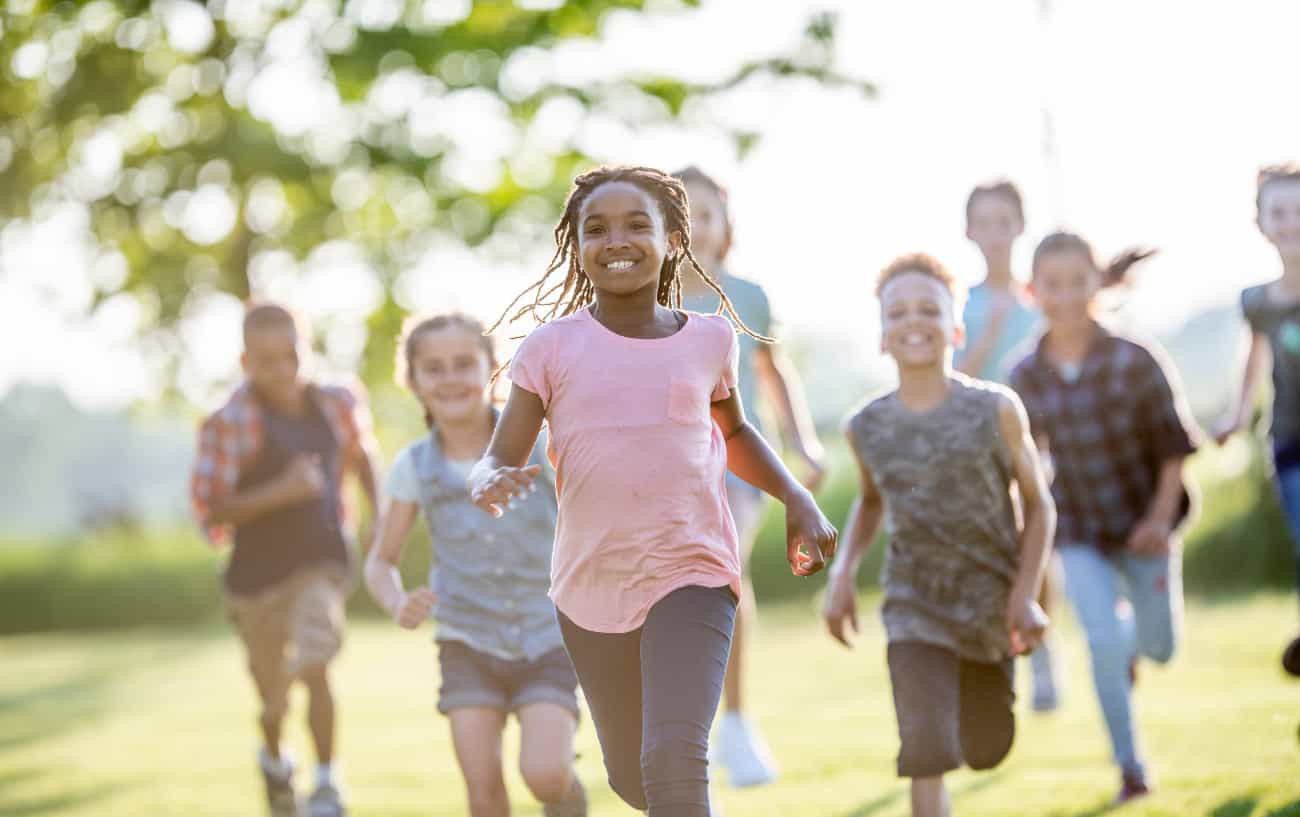 Niños corriendo en un campo.