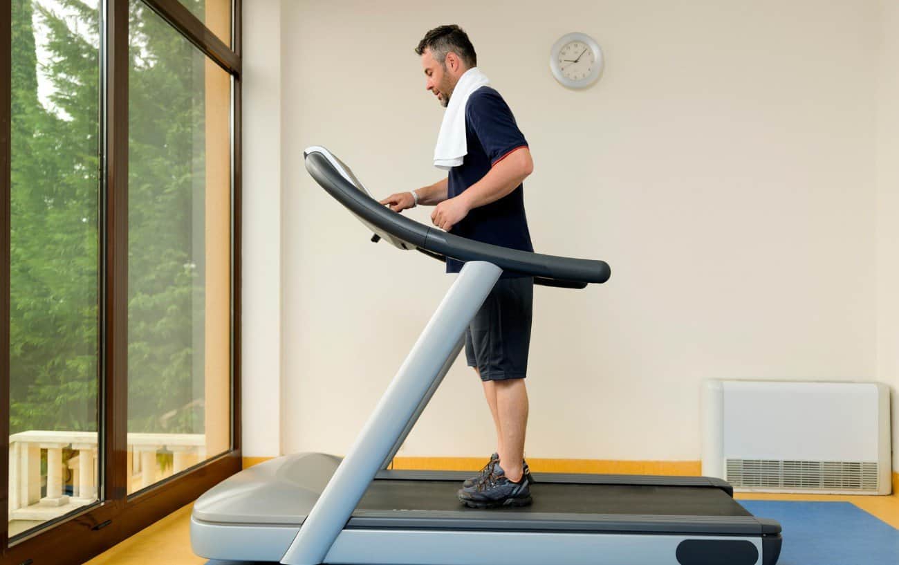 Hombre preparándose para usar una cinta de correr.