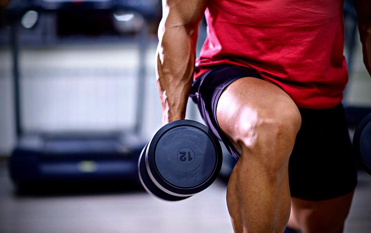 A person doing a lunge with dumbbells.