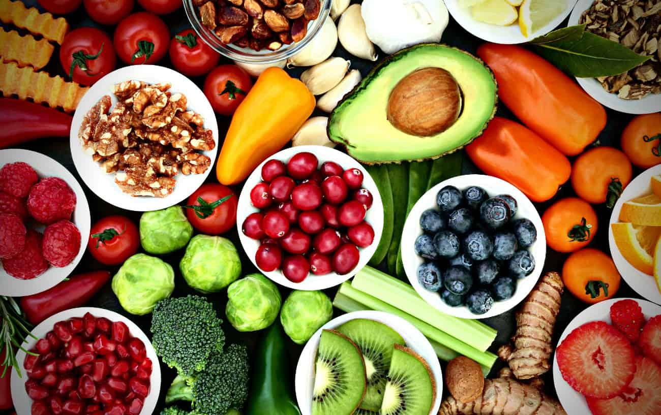 A variety of healthy foods including berries, avocados, veggies and fruits.