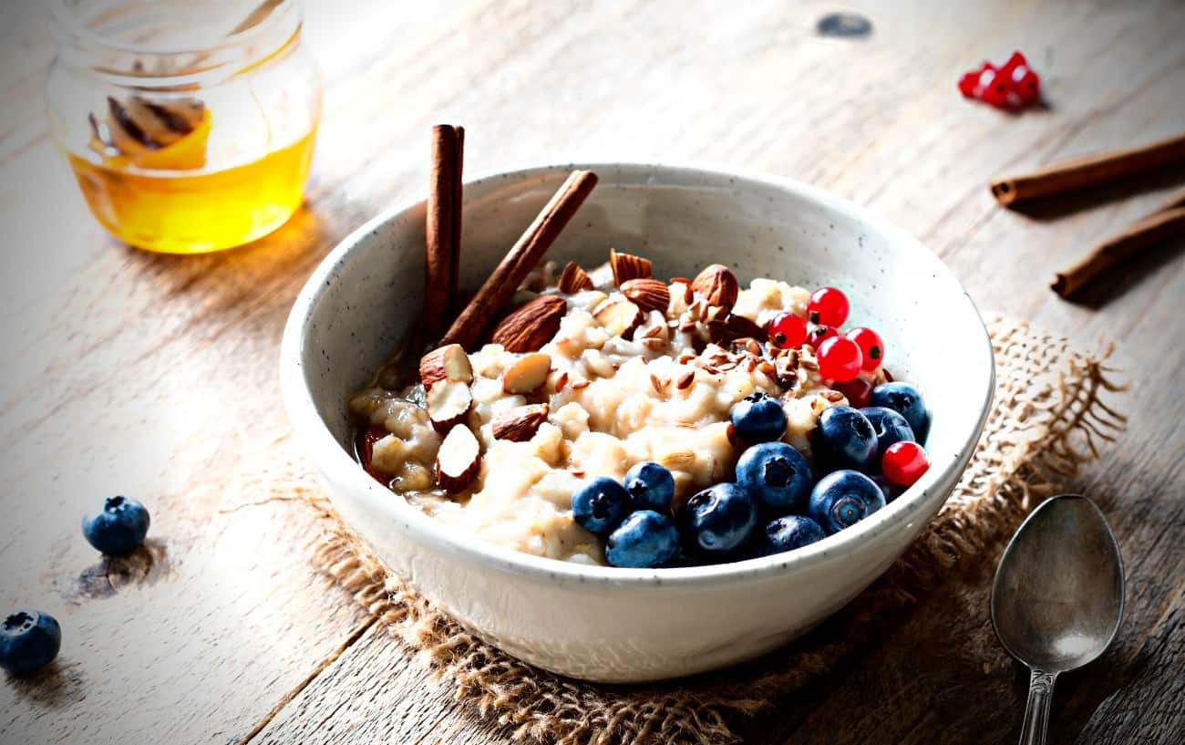 Un tazón de avena con arándanos, nueces y miel.