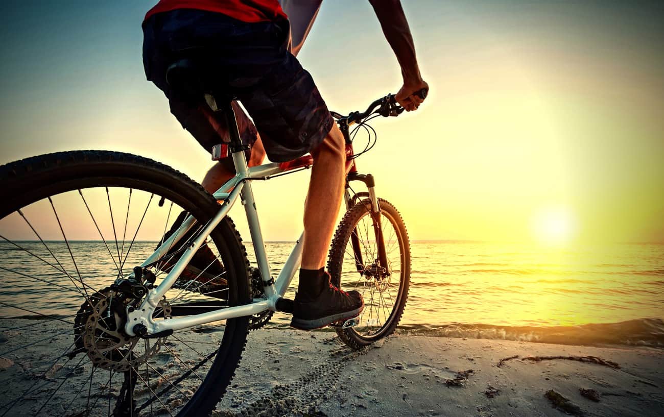 Una persona andando en bicicleta en la playa.