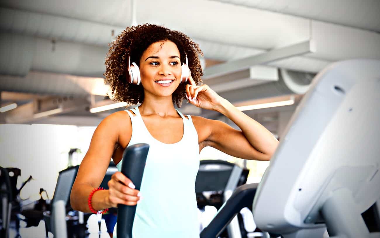 Una persona en una cinta de correr con auriculares puestos.