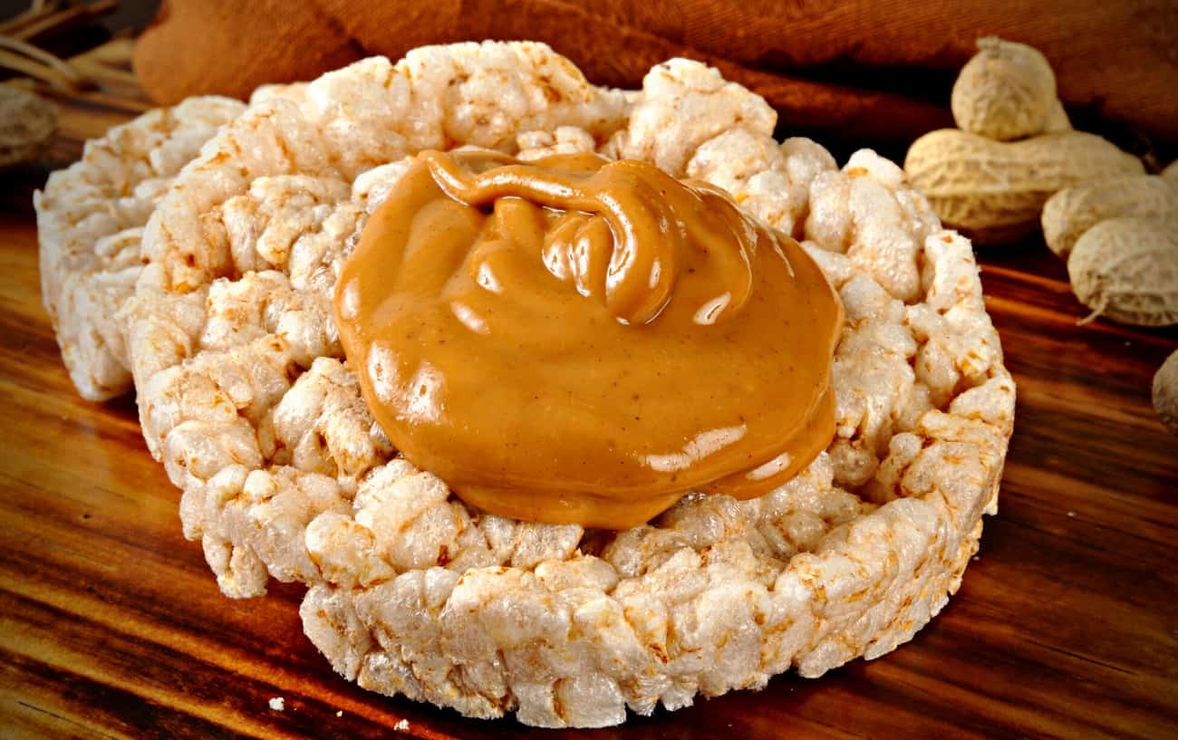 A rice cake with peanut butter on top.