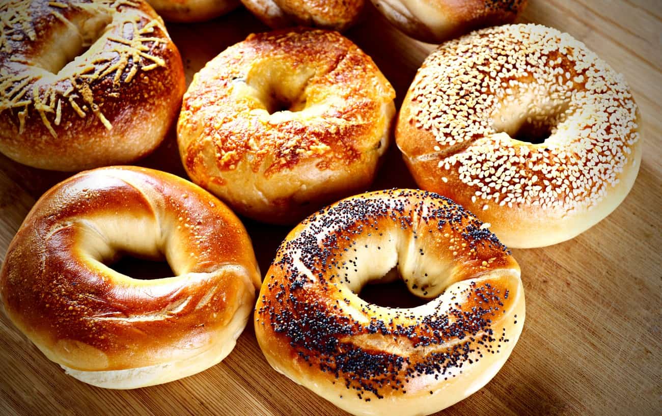 Nhiều loại bánh mì bagels trên một cái bàn gỗ.