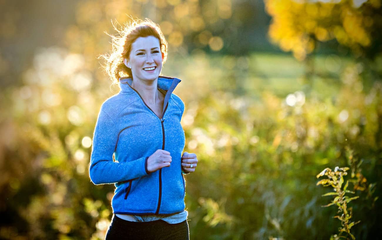 Una persona corriendo y sonriendo.