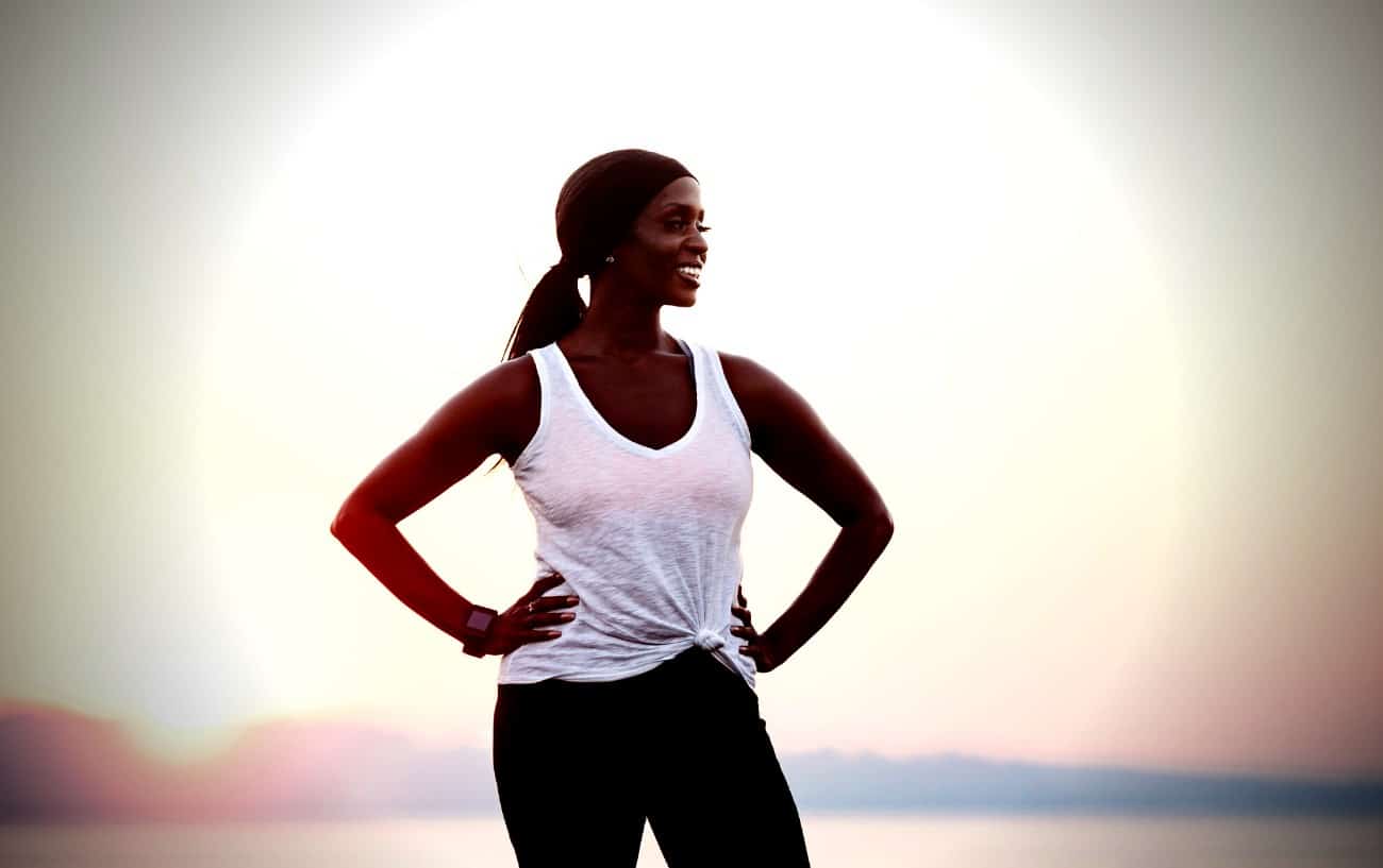 A person with their hands on their hips, smiling.