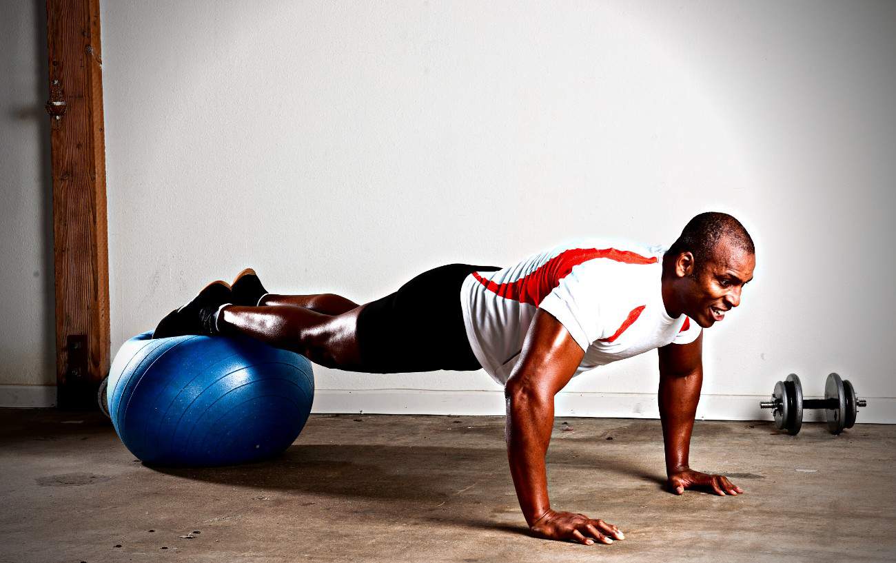 A person doing a push up on an exercise ball.