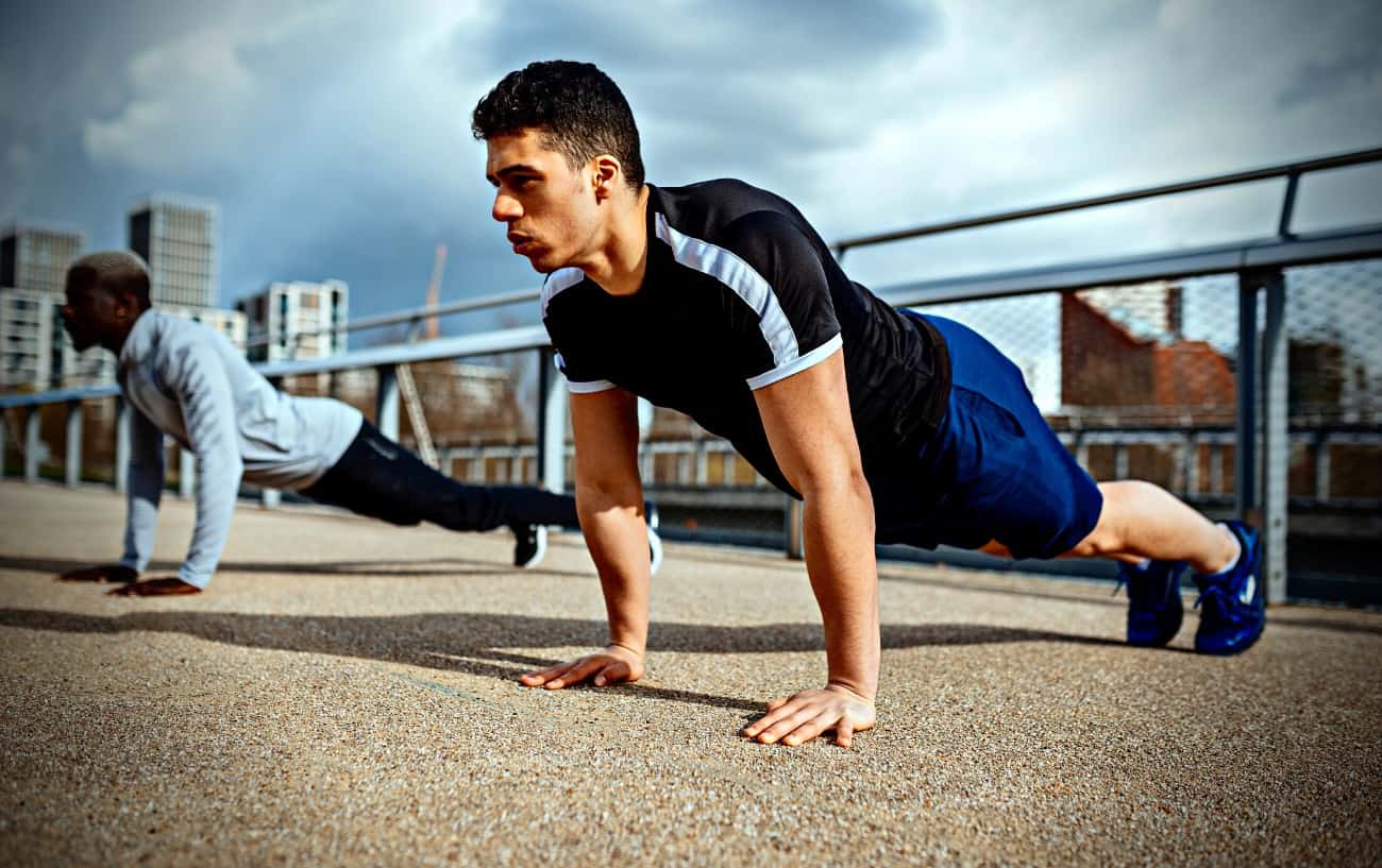 Personas haciendo flexiones afuera.