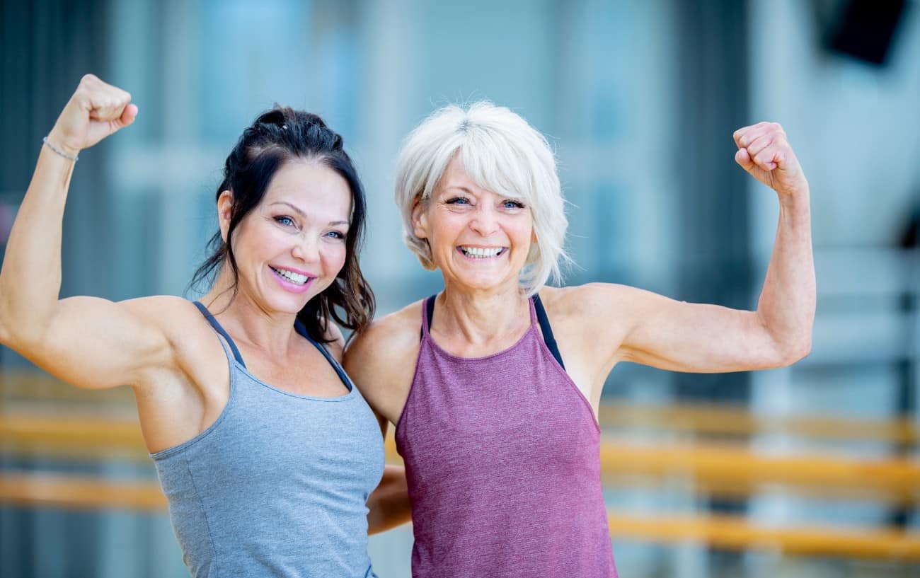 Two people smiling and flexing their biceps.