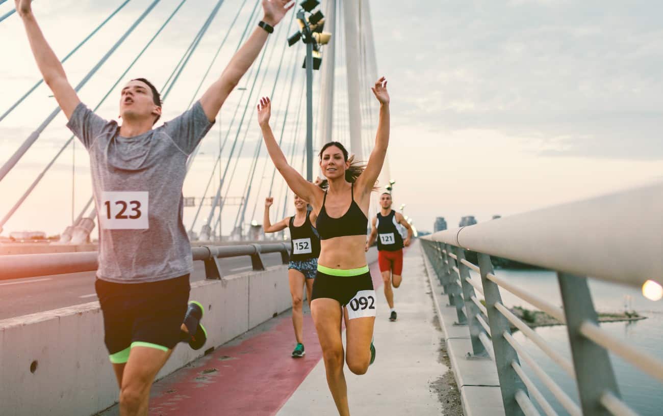 Personas corriendo sobre un puente.