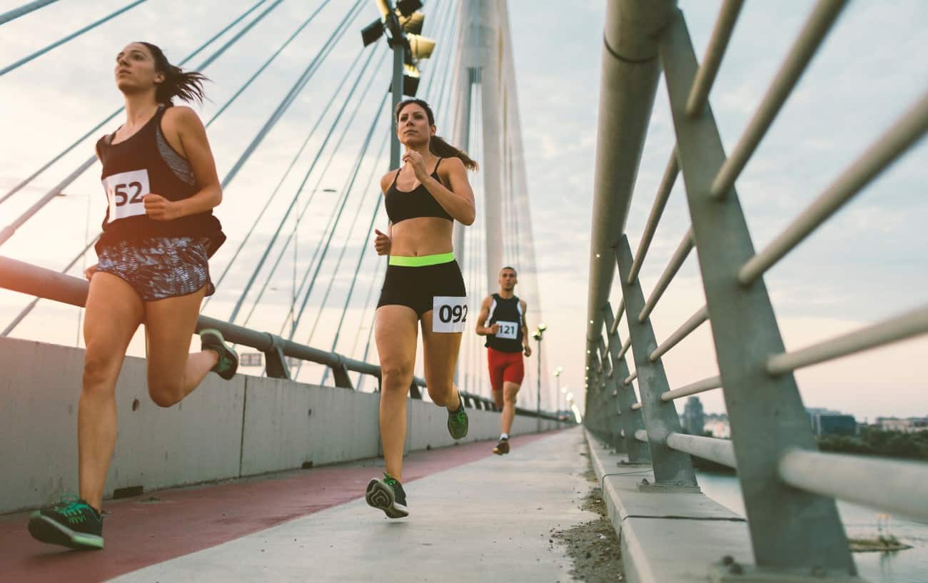 People running over a bridge in a marathon.