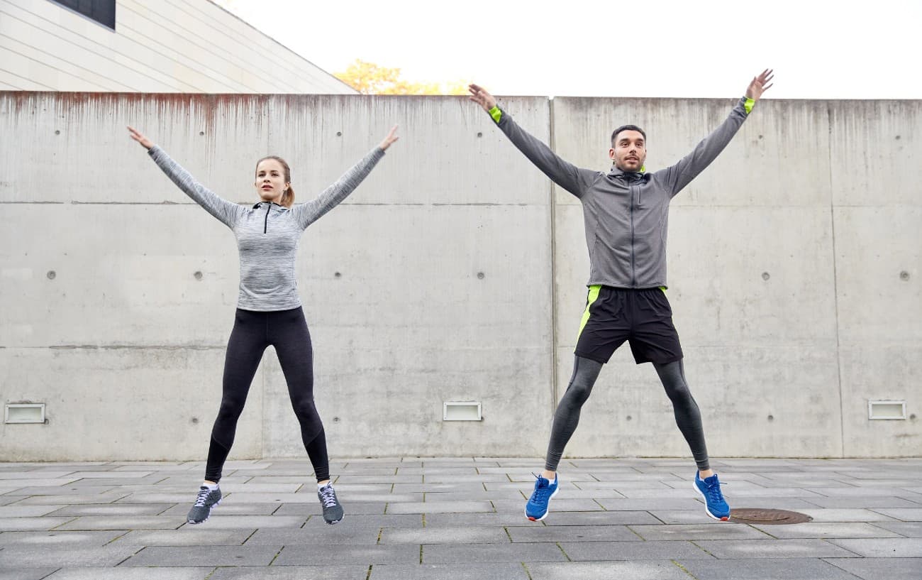 Two people doing jumping jacks, a way on how to poop before a urn by stimulating the system.