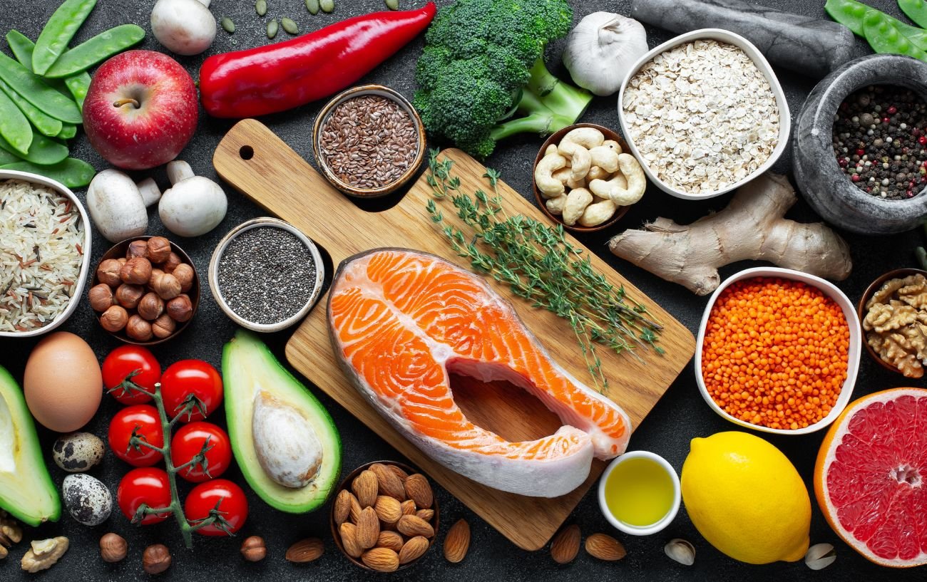 A variety of healthy foods including fish, lentils, fruits, vegetables and nuts.