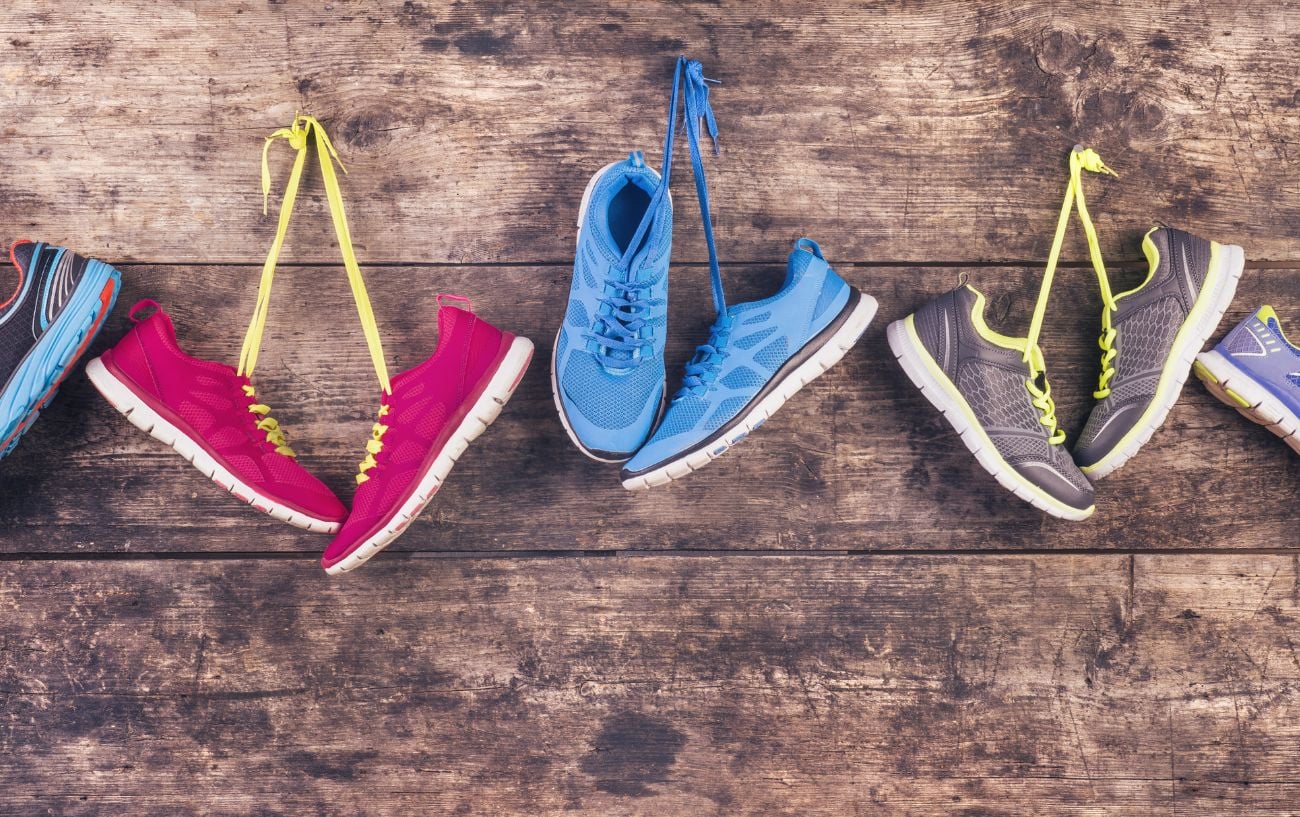 Five pairs of running shoes hanging on nails. 