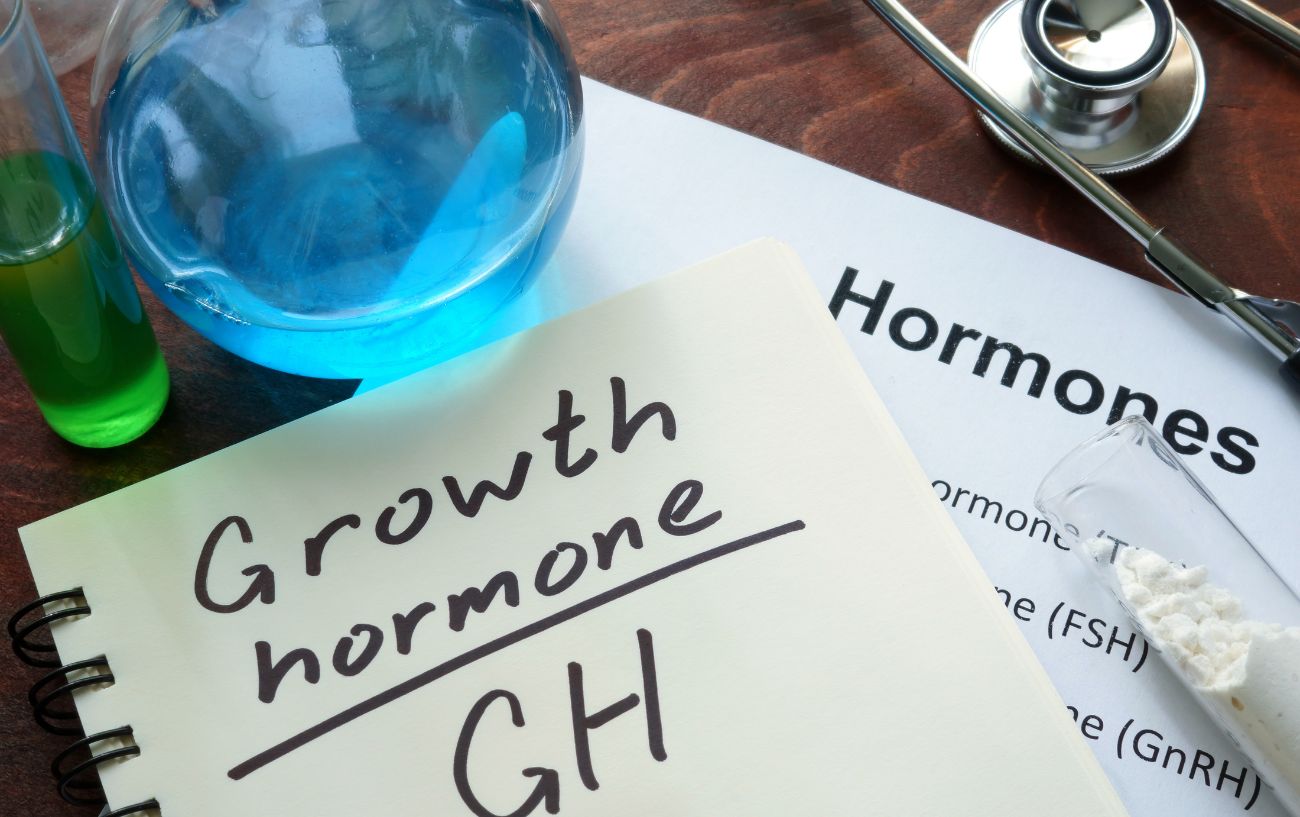 Một tờ giấy với các từ hormone tăng trưởng và thiết bị lap xung quanh.