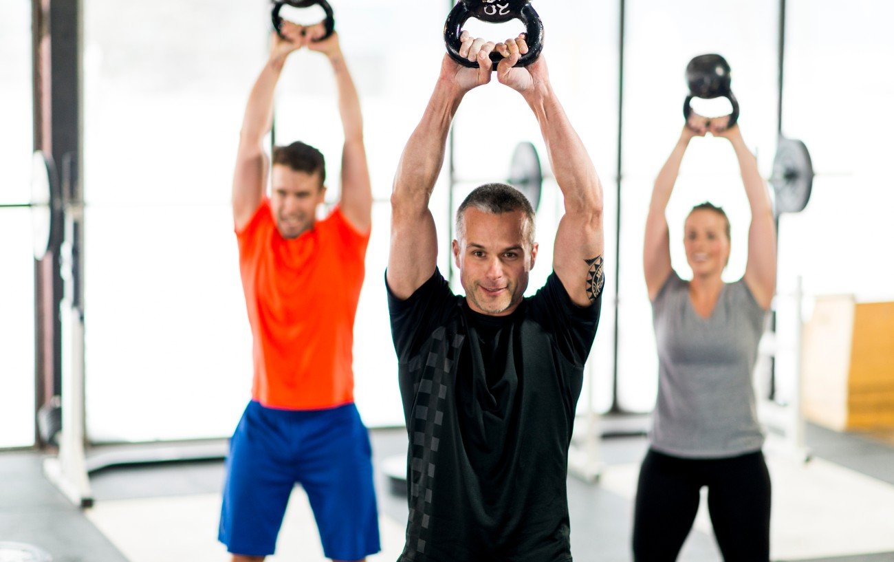 Personas haciendo swings con kettlebell.