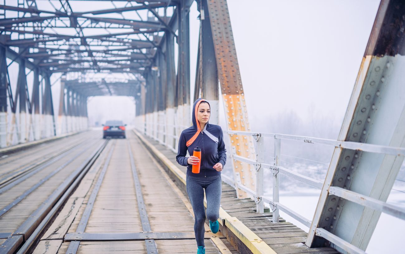 Alguien corriendo por un puente en invierno.