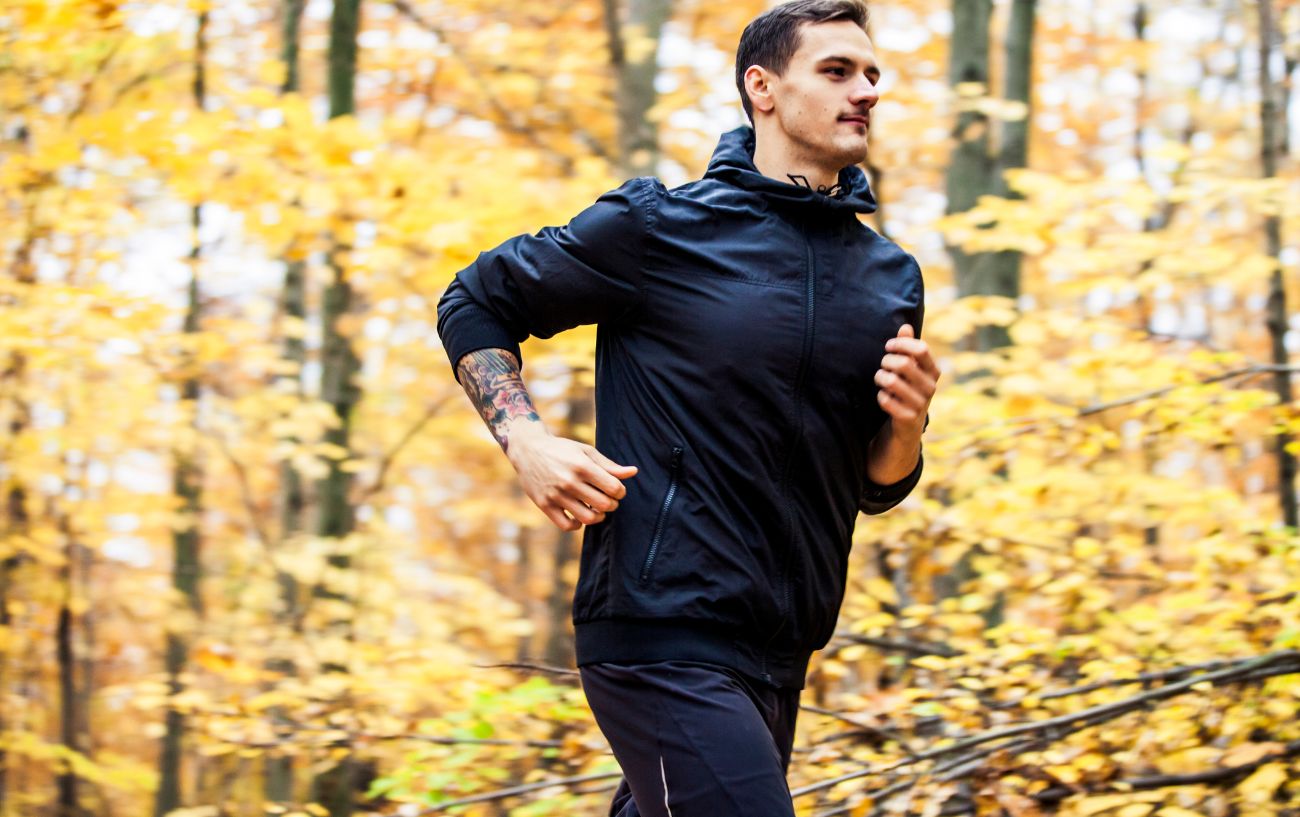 A person running on a trail on a fall day.