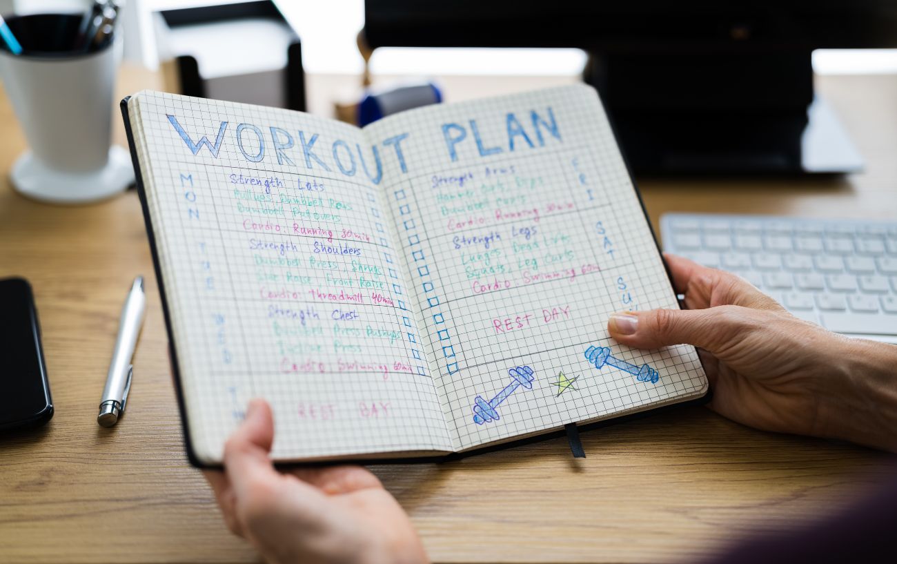 Una persona sosteniendo un plan de entrenamiento.