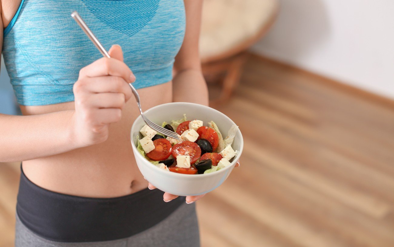 Una persona comiendo una ensalada después de hacer ejercicio.