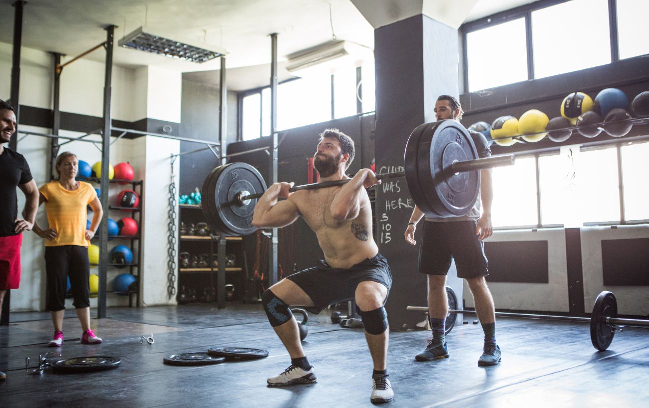 Personas levantando pesas en un gimnasio.