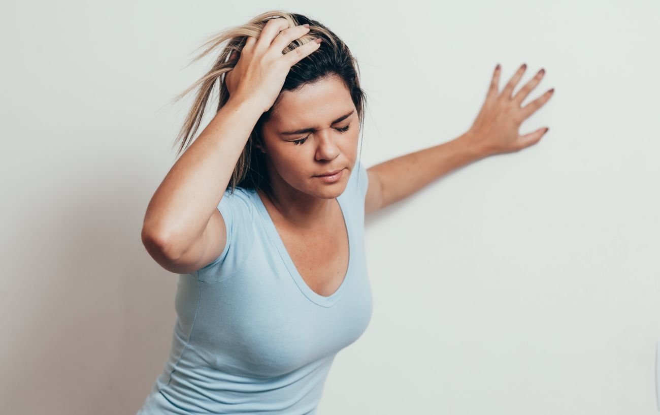 A person holding their head feeling dizzy.