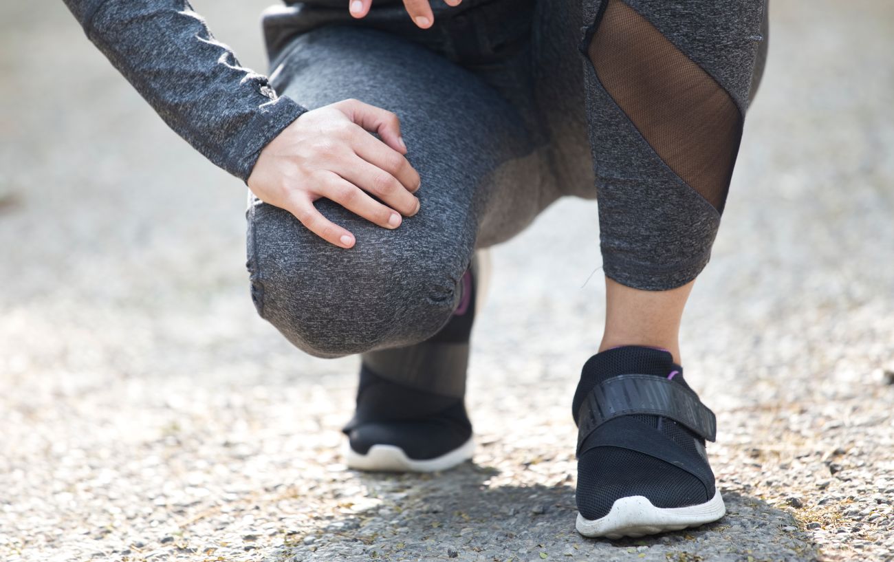 A runner hunched over on the ground.